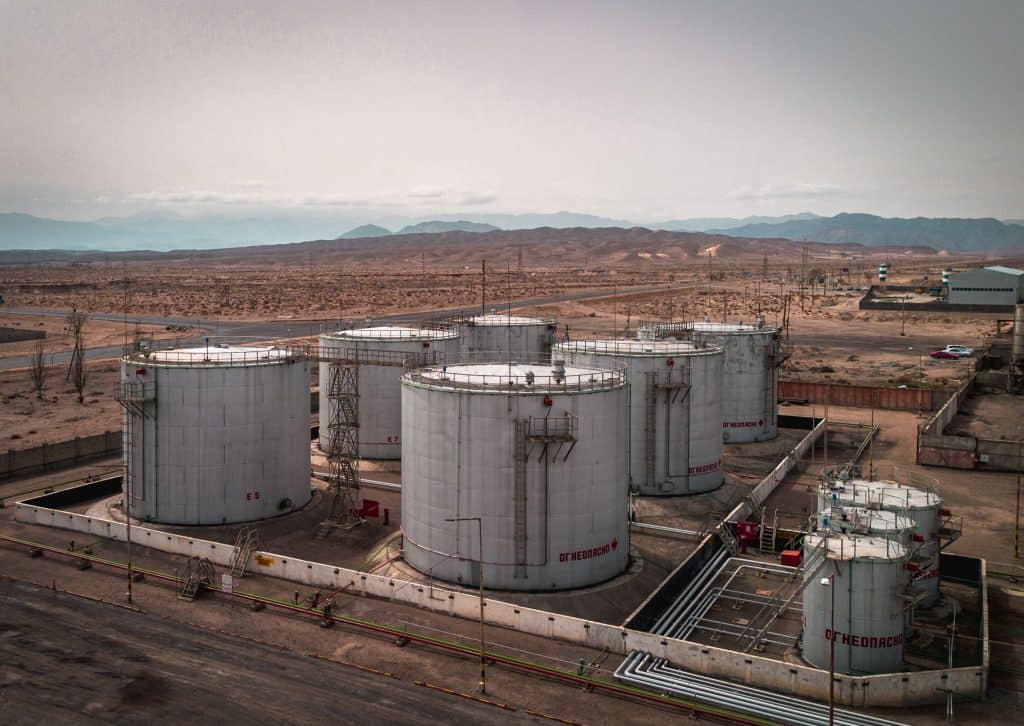 Vue aérienne de réservoirs pétroliers en plein désert, illustrant la rébellion au Niger et les menaces sur le pétrole d'Agadem